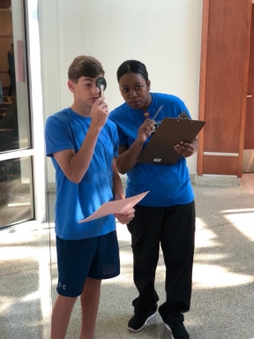 Ashley Watson, a Certified Nursing Assistant at North Oaks Medical Center, takes 13-year-old Drew Milton of Saint Thomas Aquinas Regional Catholic High School through the paces of his eye exam.